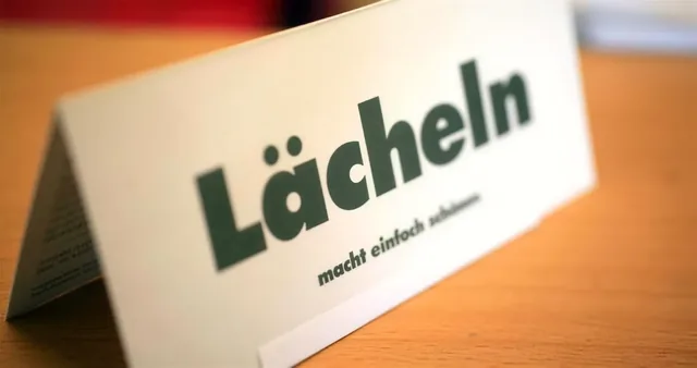 Tischaufsteller mit der Aufschrift: Lächeln macht einfach schöner