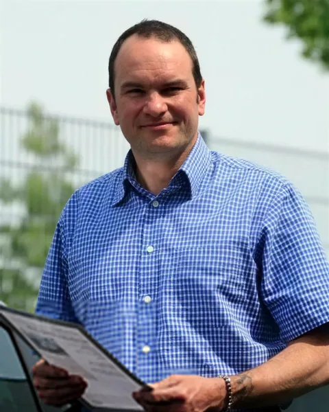 Stephen Brandrick, Verkaufsleiter, mit Unterlagen